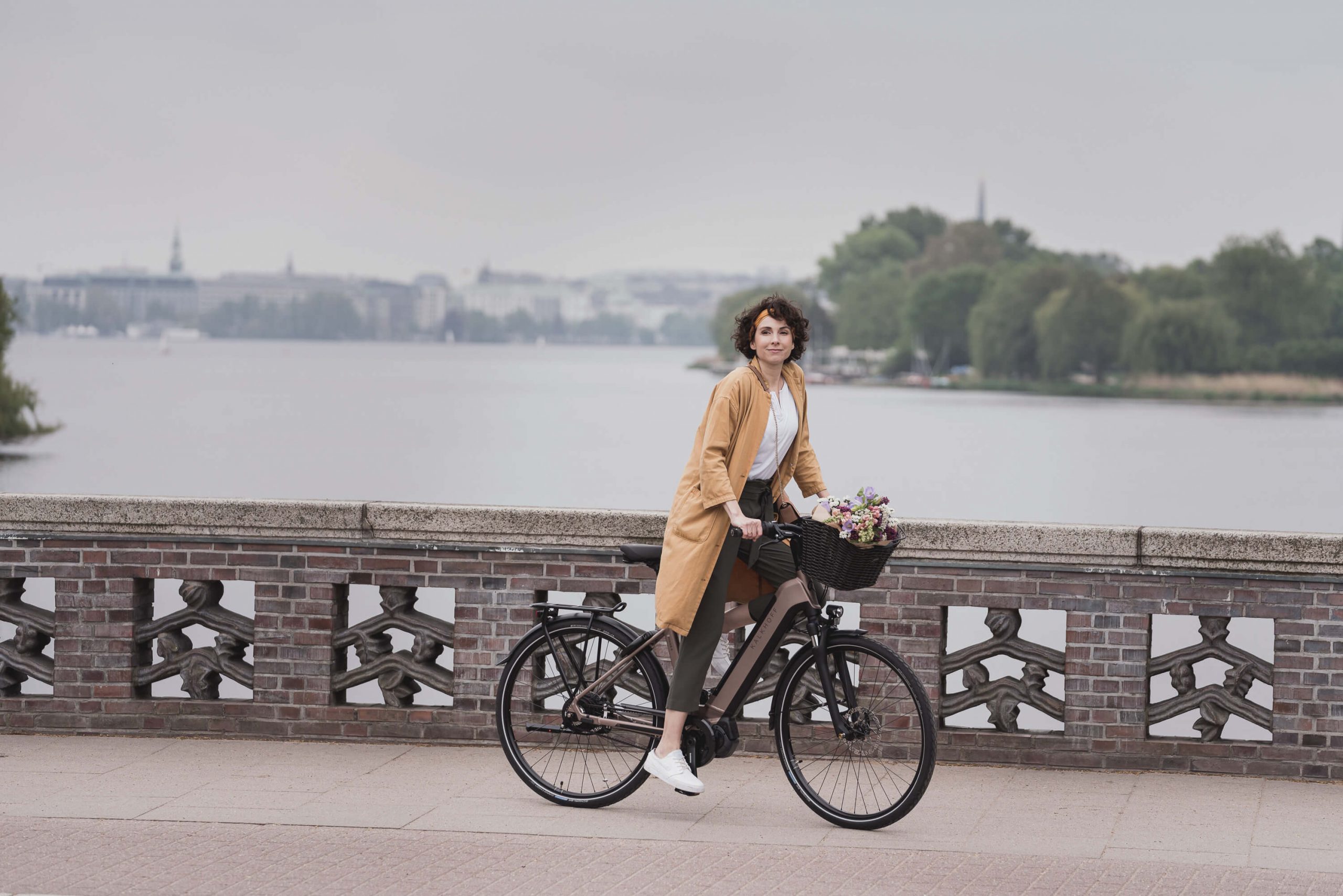 Frau fährt E-Bike auf einer Brücke